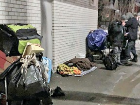 A group gathers and one person sleeps outside Hope's Kitchen at the corner of Cassells Street and Fifth Avenue West. 
Jennifer Hamilton-McCharles/The Nugget