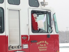 Santa Claus waves from the passenger seat of a fire truck during a drive-through visit at Memorial Gardens, Sunday.
PJ Wilson/The Nugget