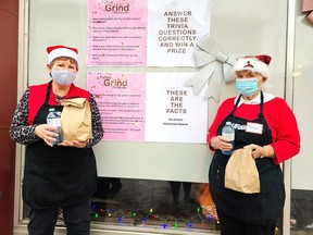 Leann Rollins (left) and Marlyn Sauk, volunteers at The Grind Pembroke Community Kitchen, were busy elves preparing and serving up bagged lunches for supporters and community members during the Feed the Need fundraiser Dec. 14. The event raised $2,500 for The Grind.