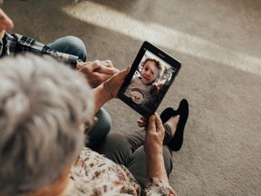 Garry and Vivien Hodge chat with their grandson, Roman Acres, on a device provided by Project Joy, an organization that hands out cellphones and tablets for seniors isolated due to COVID-19.