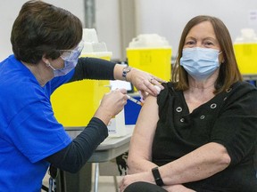 Public health nurse Tracy Benedict gives the very first London-area COVID-19 vaccine Wednesday to Karen Dann, a registered nurse and administrator at the Country Terrace long-term care in Komoka. Dann said she was overjoyed  the vaccine was here for long-term care workers and urged everyone to get inoculated.
The London Health Sciences Centre and Middlesex-London health unit have set up the facility to give shots to the region's health-care workers at the Western Fair Agriplex.
Mike Hensen/The London Free Press/Postmedia Network