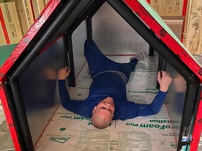 Todd Provincial lies inside a portable, insulated shelter he helped construct, demonstrating how much space and comfort it would provide for someone who lacks a proper roof over their head. Supplied