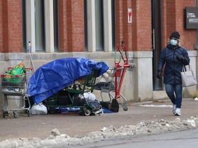 A homeless person rests in front of the McEwen School of Architecture on Elgin Street in late November.