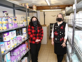 Cherie Bonhomme, left, and Debbie Jongsma, of the Pregnancy Care Centre and Infant Food Bank, stand near shelves containing food items and diapers at the location in Sudbury, Ont. on Monday December 14, 2020.