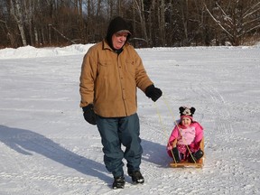 Gilles Lanteigne gives his granddaughter, Abigail Taylor, 2, a ride on a sled in Sudbury, Ont. on Monday December 14, 2020.