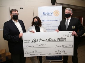 Rotarian David Farrow, left, presented a $1,000 cheque to the Elgin Street Mission on behalf of himself, his wife Catharine, and son Wilson, in Sudbury, Ont. on Tuesday December 15, 2020. Amanda Robichaud, executive director of the mission, and Gerry Lougheed Jr., chair of the Food Fund, accepted the donation for the Elgin Street Mission.