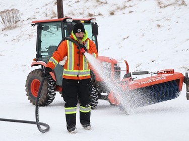 City employee Chelsea Samarian builds a base coat of ice for the skating oval at Queen's Athletic Field in Sudbury, Ont. on Wednesday December 16, 2020. John Lappa/Sudbury Star/Postmedia Network