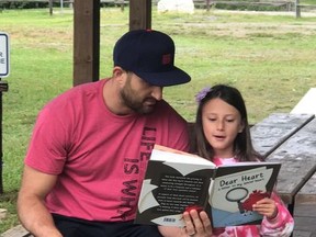 Nick Foligno listens while his daughter, Milana, reads from Dear Heart.
