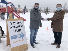 Bryan Neeley, with the Newmont Goldcorp, on left, presented a $50,000 cheque to Brian Marks, chair of the Youth Wellness Hub's board of directors on Saturday.

RICHA BHOSALE/The Daily Press