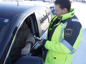 Timmins Police Service Const. Chris Gauthier conducts a mock roadside spot check on Tuesday. TPS is reminding motorists that traffic officers will be out in full force on New Year's Eve on the watch for impaired drivers. 

RICHA BHOSALE/The Daily Press