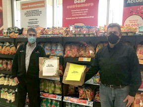 Butch Dionne presents Claude Rocheleau with a couple from the 1000 bags that were given to the Food Bank by patrons of Dionne's valu-mart.TP.jpg