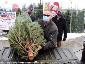 Kiwanis Club of Owen Sound members Greg Rodgers, left, and Paul Strimas, centre, load a Christmas tree onto a pick-up truck Friday. Looking on is local Kiwanis president Andrew Drury. DENIS LANGLOIS