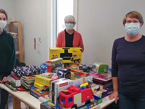 Aloria Skelding, youth ambassador for West Elgin Community Health Centre's Youth Task Team, left, Brenda Szusz from the Caring Cupboard in Rodney, centre, and Lin McCann from the Dutton Daffodil Society, right, are shown with some of the items collected through the Share-A-Toy Christmas Drive in December.