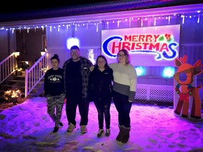 The Clark family poses in front of their home and new Merry Christmas sign. Dave Clark made the sign himself using 770 lights.
Brigette Moore