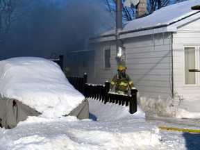 Firefighters emerge from the thick smoke of a shed fire on Oakwood Avenue Thursday afternoon. No injuries were reported in the blaze that was reported shortly before 2 p.m.
PJ Wilson/The Nugget