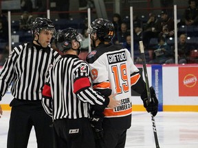 Tyler Shaw, left, speaks with a referee and player during an NOJHL game in October 2019.