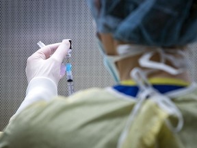 A pharmacy staffer at Kingston Health Sciences Centre prepares doses of the Pfizer-BioNTech COVID-19 vaccine.