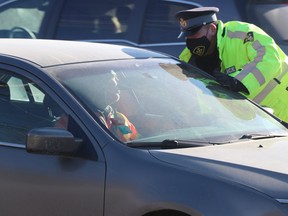 An Ontario Provincial Police officer speaks to a driver during a Festive RIDE launch on McNabb Street in Sault Ste. Marie, Ont., on Tuesday, Dec. 1, 2020. (BRIAN KELLY/THE SAULT STAR/POSTMEDIA NETWORK)