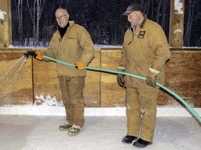 Bruce Gregoire (left) and Ken Lamming work as a team last January to flood the rink in Prince Township’s events pavilion. MARGUERITE LA HAYE