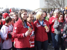 Gold medal-winning women's hockey players Rebecca Johnston, left, and Tessa Bonhomme flank Greater Sudbury Mayor John Rodriguez during a celebration of the city's four Olympians on Wednesday at Tom Davies Square.