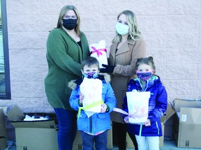 Willow Park kindergarten teacher Jenna Haugan (right) was joined by students (front, l-r) Renly Fergusson and Ryan Berube as they dropped off 42 blankets for the Leduc HUB Overnight Winter Shelter. HUB executive director Susan Johnson (left) greeted them outside to accept the blankets. (Alex Boates)