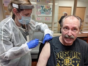 Riverview Gardens resident David Harris receives his first dose of a COVID-19 vaccine from paramedic Ashley Veendeman at the long-term care home in Chatham, Ont., on Monday, Jan. 25, 2021. (Photo courtesy of Liz Stewart)