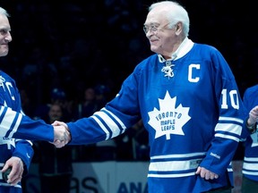Toronto Maple Leafs alumni George Armstrong, right, and son of Maple Leafs alumni Syl Apps, Syl Apps Jr., shake hands during a pre-game ceremony before the Toronto Maple Leafs and Winnipeg Jets NHL game in Toronto on Saturday, February 21, 2015.