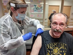 Riverview Gardens resident David Harris receives his first dose of a COVID-19 vaccine from paramedic Ashley Veendeman at the long-term care home in Chatham on Monday. Photo courtesy of Liz Stewart