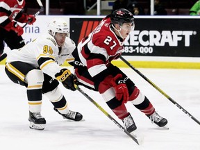 Mark Malone/Postmedia Network Jack Matier (27) of the Ottawa 67's fends off Sarnia Sting's Justin Nolet (95) in action at Progressive Auto Sales Arena in Sarnia, Ont.