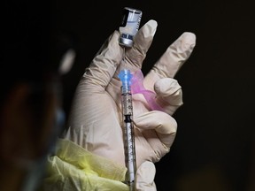 A pharmacist technician fills the Pfizer-BioNTech COVID-19 mRNA vaccine at a vaccine clinic during the COVID-19 pandemic in Toronto on Dec. 15, 2020.