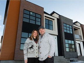 Sam and Kim Ireland pose for a photo outside their new home they will share with their three sons on Yorke Mews in the Blatchford Development in Edmonton, on Wednesday, Dec. 2, 2020.