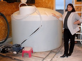 Jessica Brooks, the spokesperson for Water Wells First, displays the bypass tank needed to supply fresh water to her home, since her water well remains clogged from sediment. Photo taken north of Chatham, Ont. on Tuesday December 4, 2018. Ellwood Shreve/Chatham Daily News/Postmedia Network