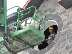 Dave Clemente (left) and Justin Brummell, of DOMM Construction, work with John Scott, of Scotiabell, to install the clock face on the tower at the West Perth fire hall Jan. 6. The 100-year-old clock, which weighs approximately 150-lbs., was lifted into place and together with the restored bell from the Mitchell post office, will chime yet again. ANDY BADER/MITCHELL ADVOCATE