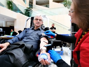 Canadian Blood Services' Sandra Madsen takes some blood from Cliff Gervais during a blood donar clinic at City Hall in Edmonton, Alberta on March 1, 2013. Perry Mah/Postmedia Network