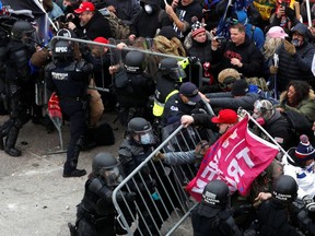 Pro-Trump protesters tore down a police barricade during riots at the U.S. Capitol Building in Washington Jan. 6, 2021.