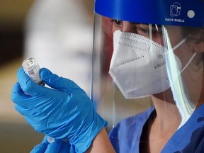 A nurse prepares a syringe with the COVID-19 vaccine.