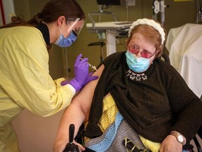 Judy McKnight receives the first dose of the COVID-19 vaccine from registered nurse Julie Denouden at the Canmore General Hospital on Jan. 6. McKnight was the hospital's first long-term care resident to receive the vaccine. Photo Leah Hennel Alberta Health Services.