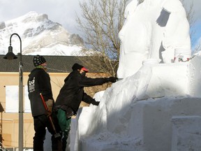 The streets of downtown Banff transform into a winter gallery for the SnowDays Snow Sculptures this month, running Jan.20-31. (Pictured) Snow sculptors, David Ducharme, originally from Quebec, and Susanne Ruseler, from the Netherlands, work on their piece Drifting Broncos on Banff Avenue on Sunday, Jan. 17. Using a blend of power and handcrafted tools to shape the translucent ice blocks. Photo Marie Conboy/ Postmedia.