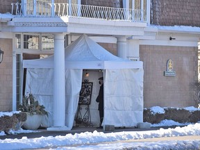 A small tent was set up at the Burke Funeral Home in Belleville Friday as part of a new drive-up visitation service held for the first time in the city. Mourners passing through the tent remained outside but were able to pay respects to the deceased resting just inside the main entrance behind a plexiglass barrier. DEREK BALDWIN