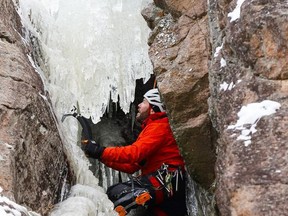 Tyler Walczak plans his route while climbing the ice of Eagle's Nest, a cliff just north of downtown Bancroft. Each winter climbers are a frequent sight on ice of the towering cliff just north of downtown. See page A3 for more photos.