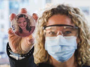 Registered nurse Jessie Price holds a button showing her face, without personal protective equipment, outside Belleville General Hospital. Some Quinte Health Care staff are wearing the buttons to let patients see their faces and give a more personal touch to care during the pandemic.