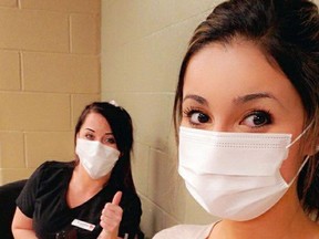 Hastings Manor registered practical nurses Meana Ahmadzai, foreground, and Leslie Johnston show their approval after receiving their first COVID-19 vaccinations Thursday in Kingston, Ont. They were the first two Manor staff vaccinated.