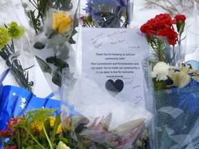 Citizens in Calgary place flowers at the location where Sgt. Andrew Harnett was killed on New Year's Eve after he was struck by a fleeing vehicle at a traffic stop. Harnett's family is from Hagersville, where he was raised. Two male teenagers, aged 17 and 19, are charged with first-degree murder. Darren Makowichuk/Postmedia

Postmedia Calgary