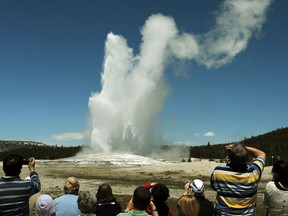 Tourists watch the Old Faithful geyser, which erupts regularly in the Yellowstone National Park in Wyoming.