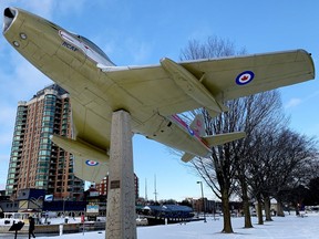 Beth Scott, at bottom left, is dwarfed by the Sabre Jet memorial on Blockhouse Island during a chilly waterfront stroll on Thursday afternoon. (RONALD ZAJAC/The Recorder and Times)