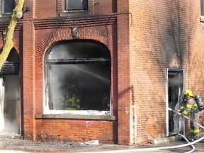 Firefighters work on dousing a hot spot of a fire that caused significant damage to a building on Victoria Street in downtown Thamesville on Wednesday. Ellwood Shreve/Chatham Daily News/Postmedia Network