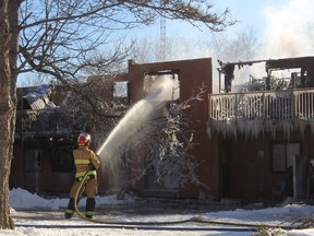 A firefighter from South Frontenac Fire and Rescue continues to hit hot spots at McMullen Manor in Verona on Friday after fire tore through the building the night before.