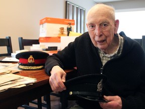 Bill Hackett, with his numerous newspaper clippings, badges, notes and old police hats on May 3, 2019. He died on Jan. 29, 2021.