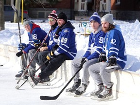 Hockey players, all dressed as Toronto Maple Leafs and many from the Queen's Gaels men's hockey team, wait for their turn to play in a spirited game of shinny in cold temperatures at Victoria Park on Friday.
