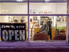 Heather Tomshak of Central Barber Shop gets Willy Jabs a trim on Wednesday, the second day the shop was open this week,after the province eased restrictions on barbers, hair dressers, tattooists and businesses that provide piercing services. 
RANDY VANDERVEEN